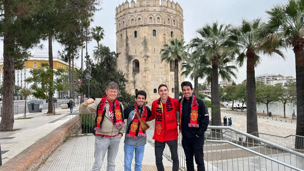 Aficionados del Mallorca posan con la Torre del Oro de fondo
