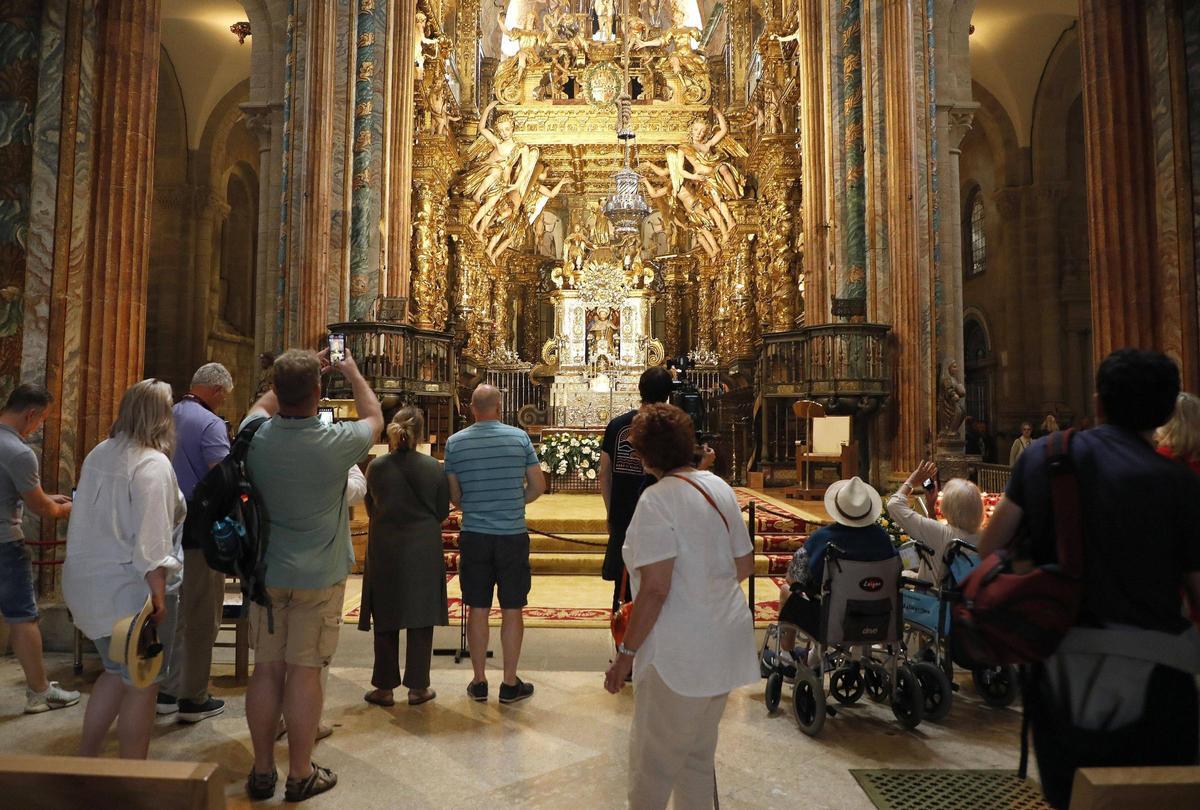 Visitantes e peregrinos observan o altar maior da Catedral de Santiago