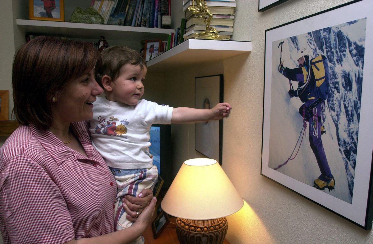 Araceli Hernández, mujer de Juanito Oiarzabal, y Mikel, hijo de ambos, observan una foto del ochomilista vasco en una imagen de 2001.