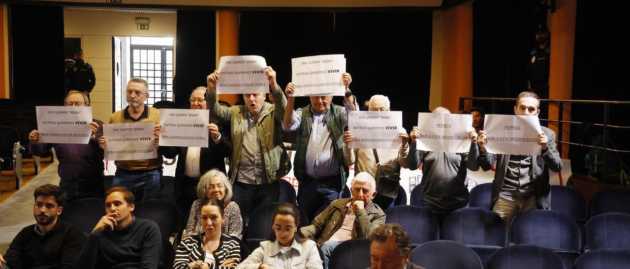 Representantes de la Federación de Vecinos Castelao acudieron al pleno con carteles que muestran su rechazo a la modificación del Peprica.