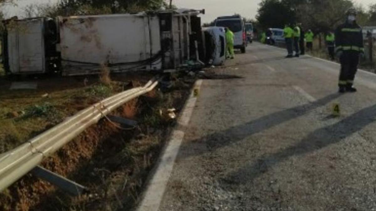 Bomberos y guardias civiles, junto al camión de recogida de basuras accidentado.