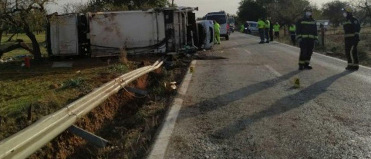 Bomberos y guardias civiles, junto al camión de recogida de basuras accidentado.