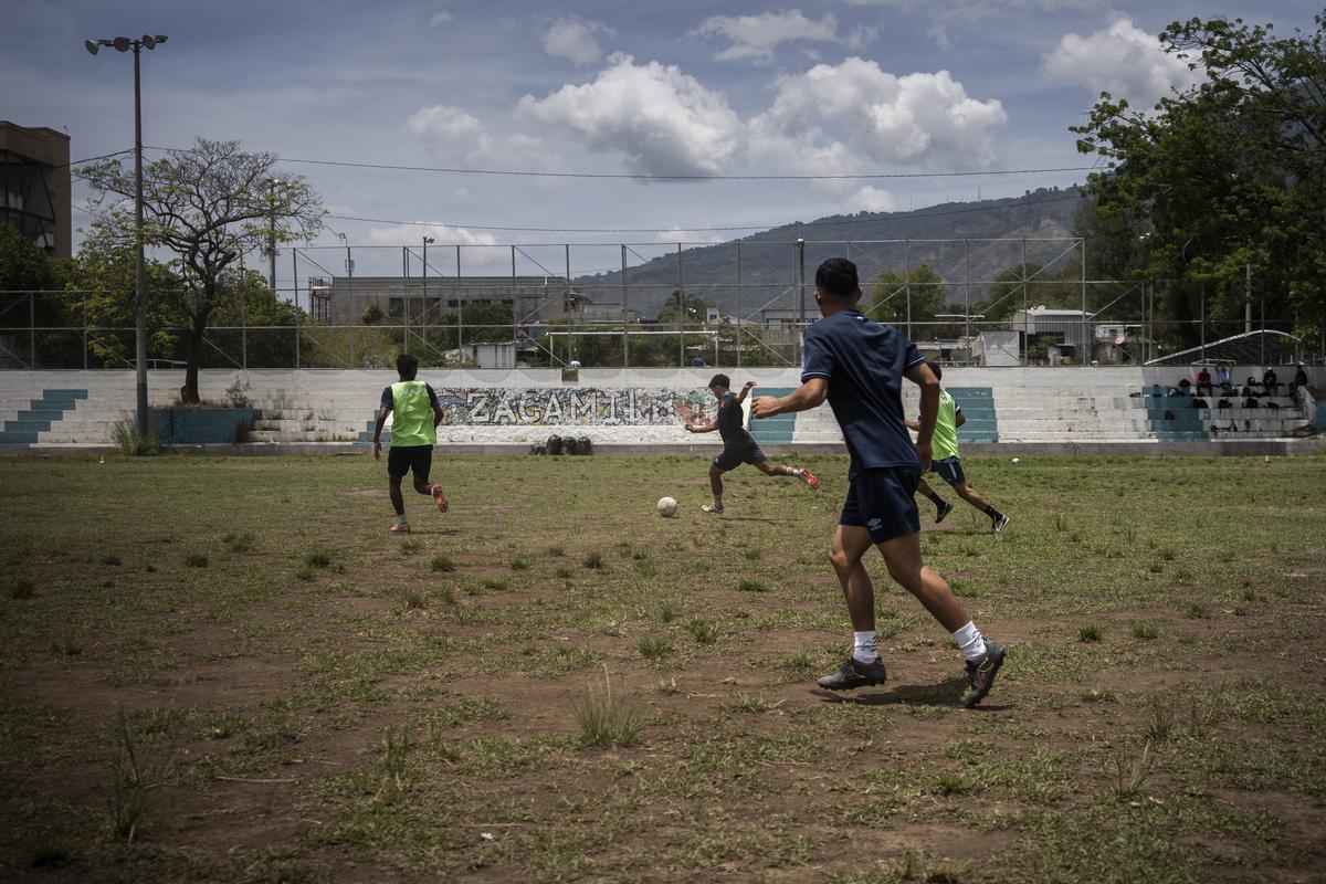 Varios jóvenes jugando al fútbol en la cancha del barrio de la Zacamil