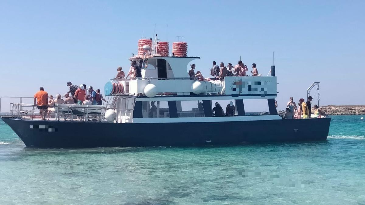 Una barca de excursiones expedientada por operar en s'Espalmador desembarca turistas en el islote.