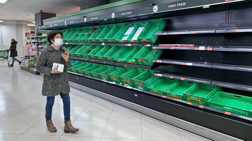 Una clienta, ayer, ante una lineal vacía de carne y fruta en un supermercado de Oviedo.