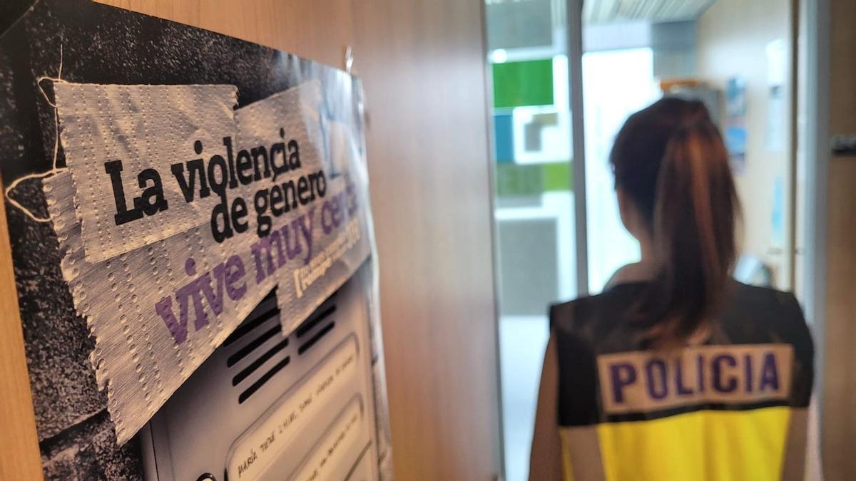 Policía Nacional con un cartel de violencia de género.