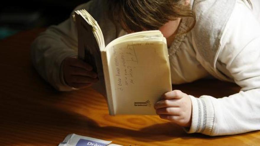 Una alumna de Primaria lee un libro.