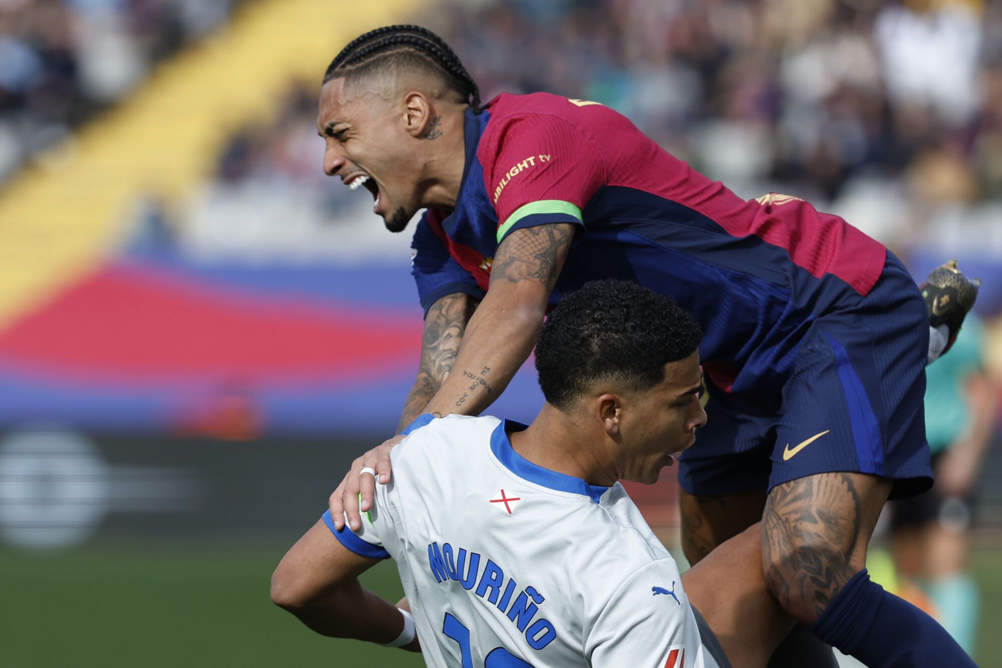 Barcelona's Raphinha, top and Alaves' Santiago Mourino collide during a Spanish La Liga soccer match between Barcelona and Alaves at the Lluis Companys Olympic Stadium in Barcelona, Spain, Sunday Feb. 2, 2025. (AP Photo/Joan Monfort)