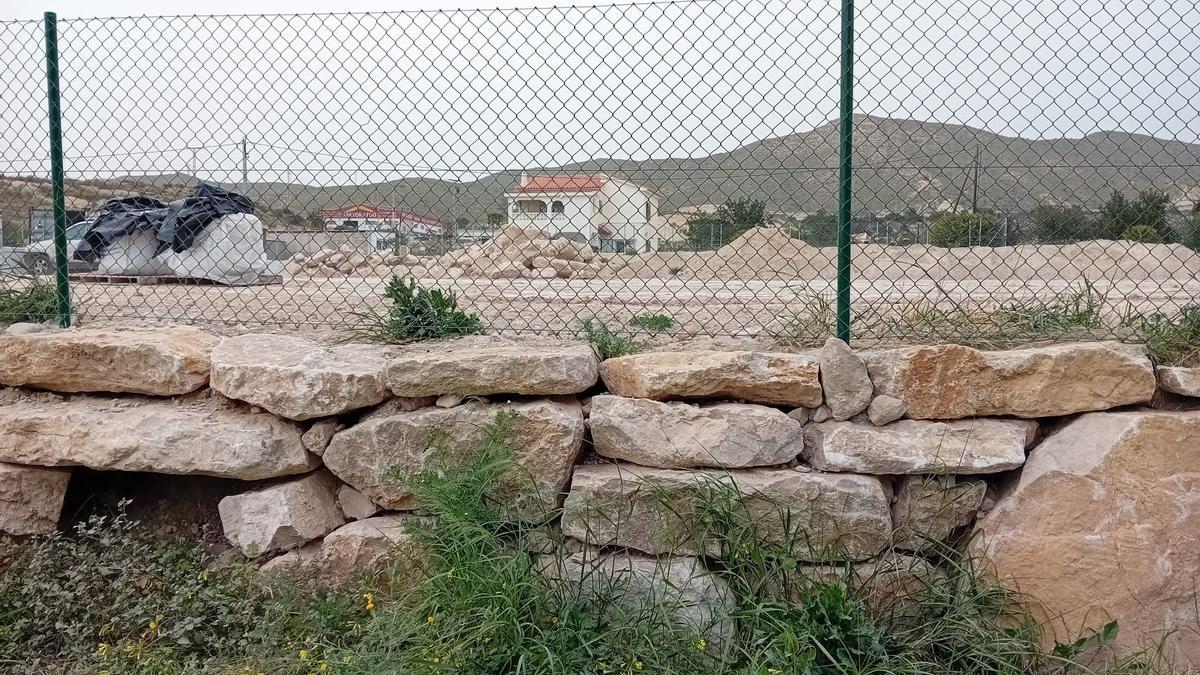 Terreno elevado, en la actualidad y, al fondo, viviendas