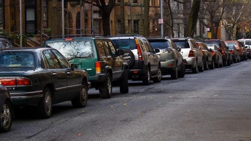 Una fila de cotxes aparcats a la via pública.