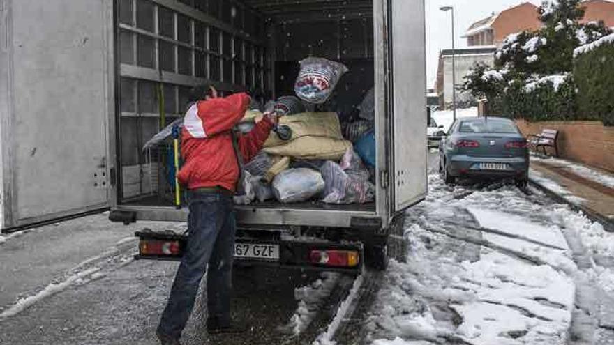 Un camionero carga ropa para familias necesitadas donada por los alumnos del colegio El Pinar.