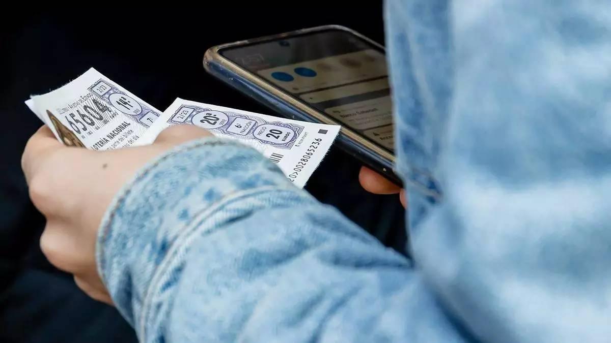 Una persona amb un parell de números de la Loteria del Nen
