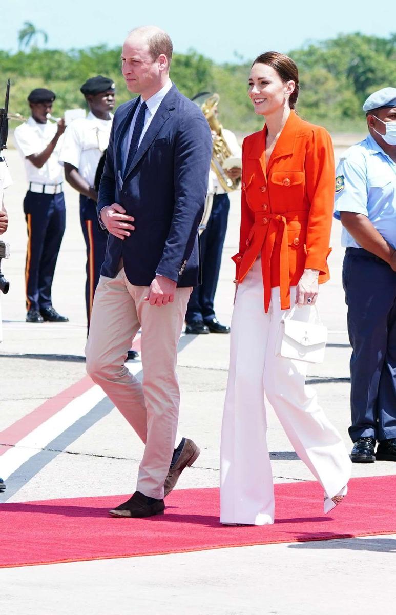 Kate Middleton con pantalón blanco y chaqueta naranja