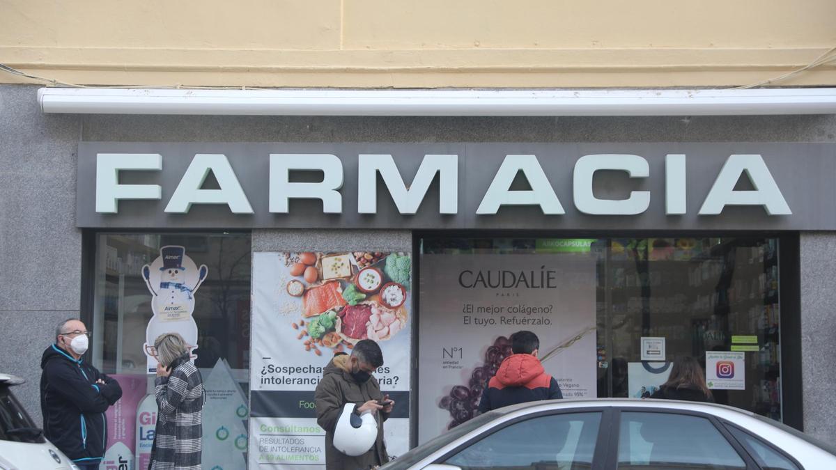 Varias personas hacen cola en una farmacia para adquirir un test de antígenos.