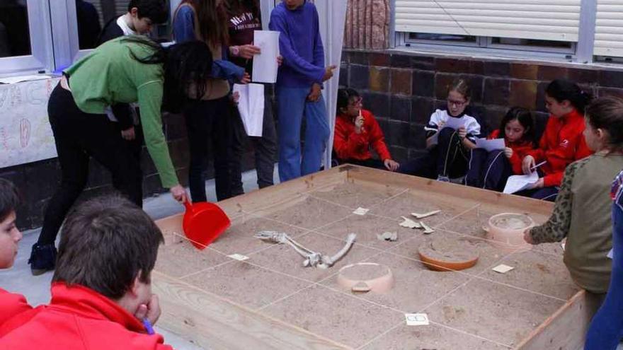 Varios alumnos trabajan sobre un improvisado campo arqueológico.