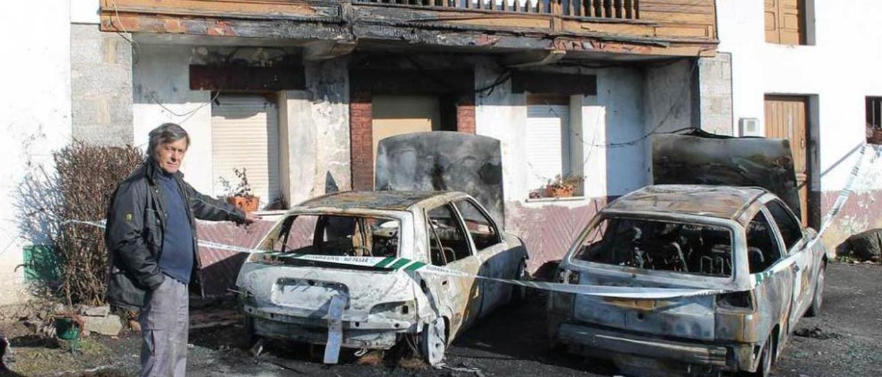 Graciano Adolfo Palacio, señalando ayer los coches calcinados junto a su casa de Feleches.