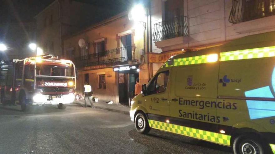 El camión de bomberos y la ambulancia a la puerta de la vivienda; a la izquierda, estado en el que quedó el colchón donde se originó el fuego en Alcañices.