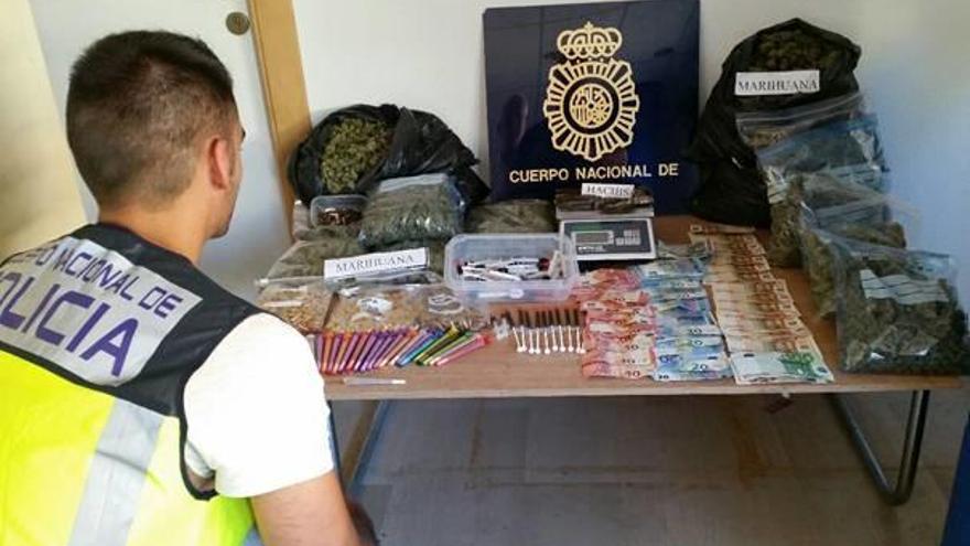 Un policía con la marihuana y otros efectos incautados en la operación.