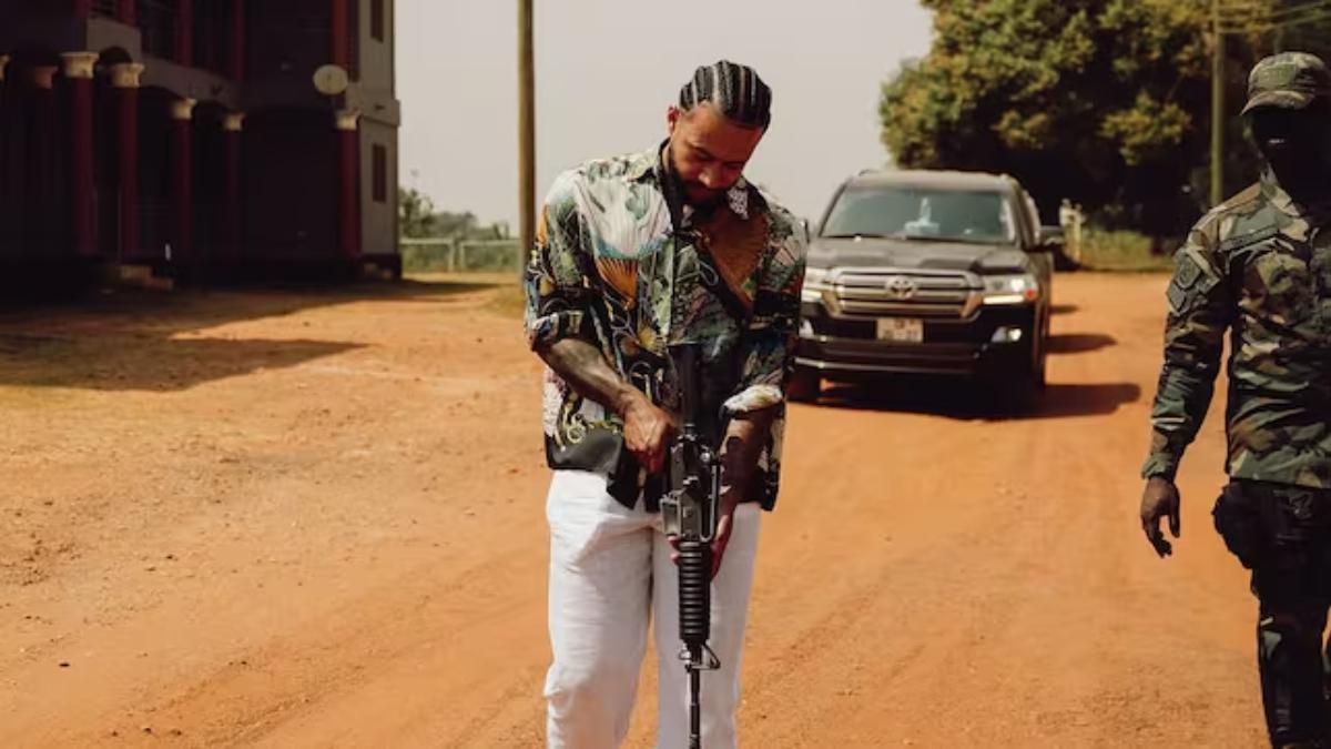 Memphis Depay sujeta un rifle en su visita a Ghana