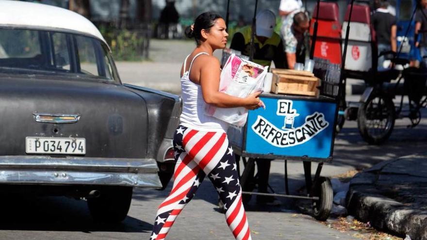 Una joven cubana camina por La Habana con un pantalón que remeda la bandera de EE UU.