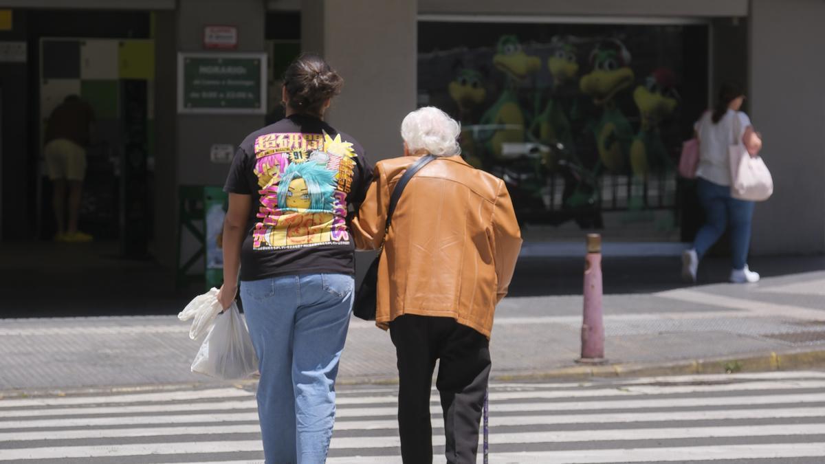 Una mujer mayor camina acompañada de su cuidadora en Gran Canaria.