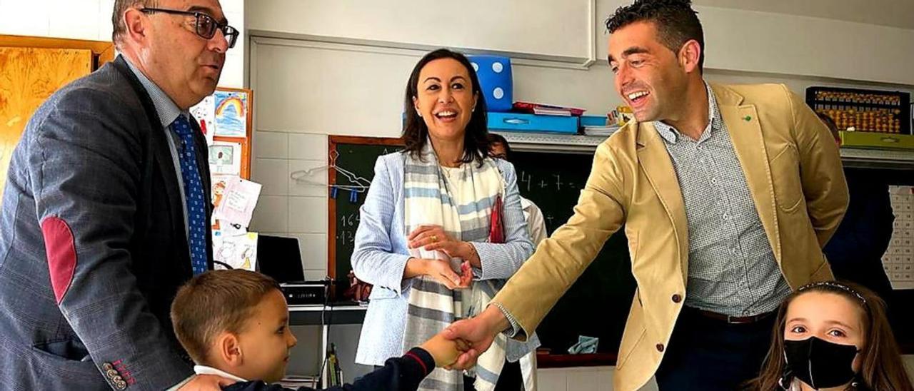 Luis López saluda a un niño en San Narciso junto María Ramallo y el jefe territorial de Educación. |   // FDV