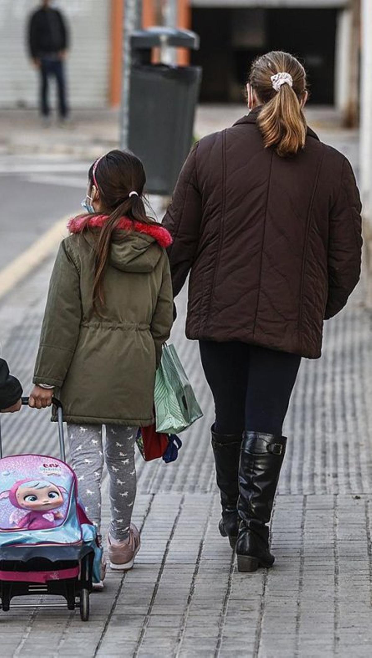 Una madre con su hija yendo al colegio.| |  FREEPIK