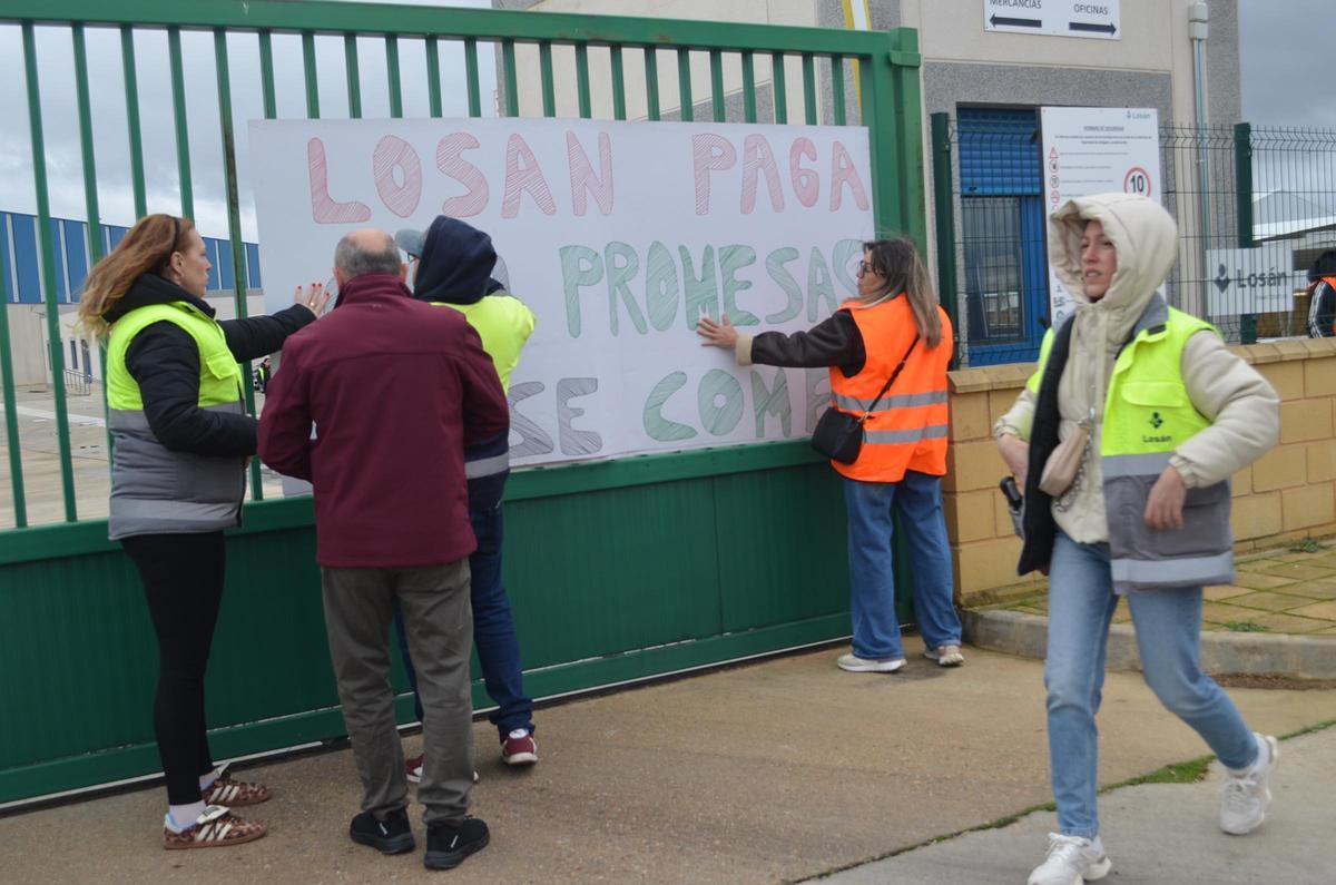 Varios trabajadores colocando una de las pancartas.
