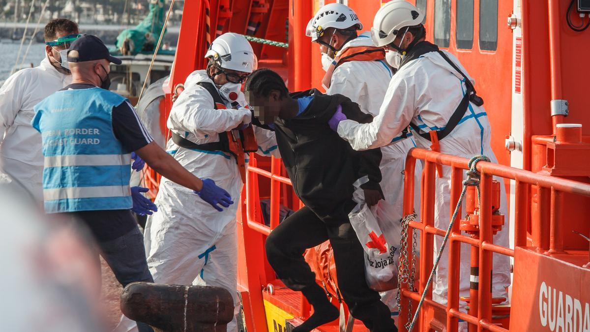 Archivo - Varios trabajadores ayudan a una mujer a salir de la embarcación de Salvamento Marítimo ‘Guardamar Talía’ a su llegada al muelle de Arguineguín con varias decenas de migrantes, a 28 de agosto de 2021, en Arguineguín, Mogán, Gran Canaria, (España