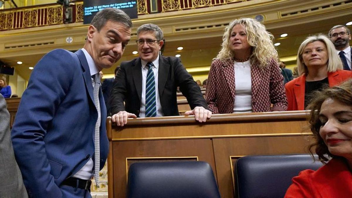 El presidente del Gobierno, Pedro Sánchez, acude a su escaño en el Congreso, junto al portavoz del grupo socialista, Patxi López, durante una sesión de control.