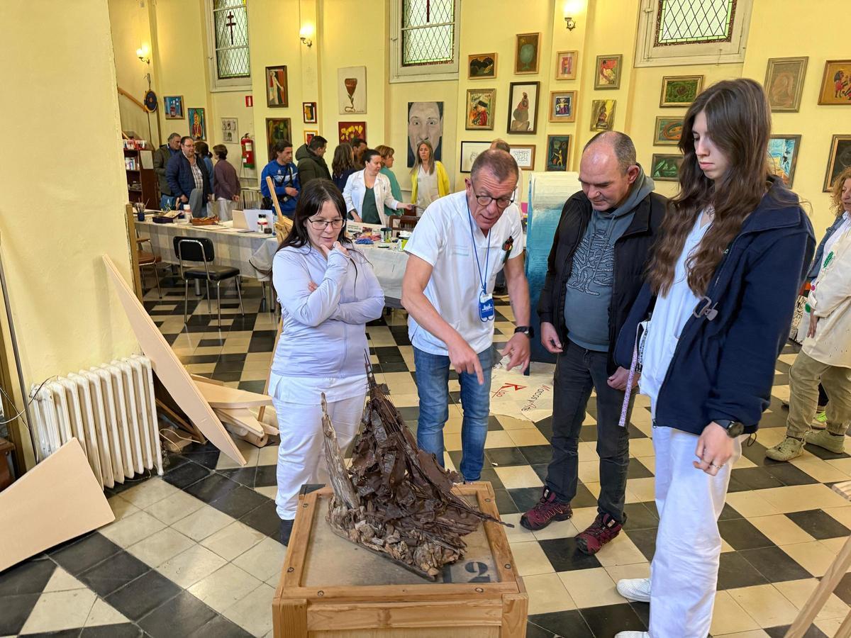 Profesionales de Piñor miran una escultura.