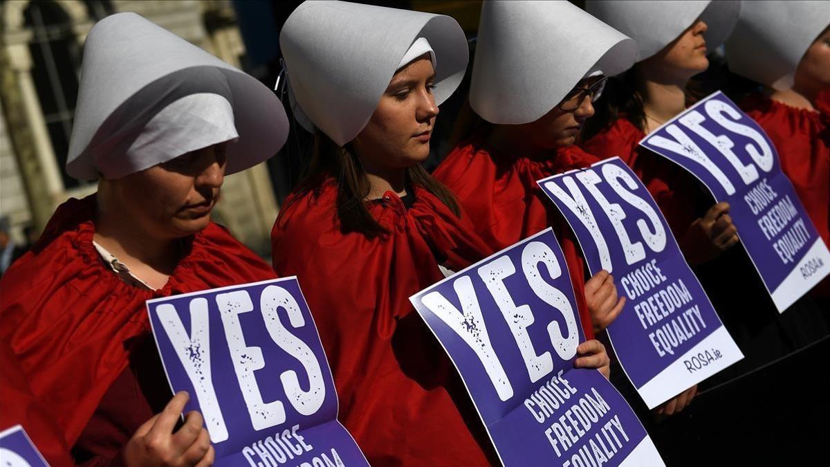 Activistas por el derecho a decidir se manifiestan en Dublín vestidas como los personajes de la serie 'El cuento de la criada' en el marco de la celebración de un referéndum sobre el aborto, que tiene lugar en Irlanda este viernes.