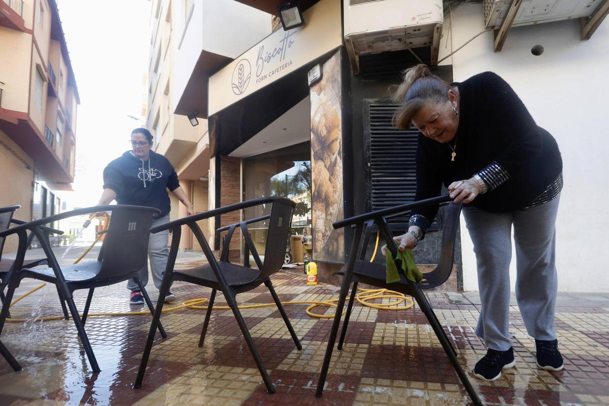 Dos compañeras de Alicía ultiman los preparativos antes de abrir el local.