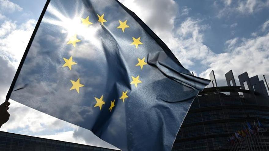 Ondean la bandera de la UE frente al Parlamento Europeo.