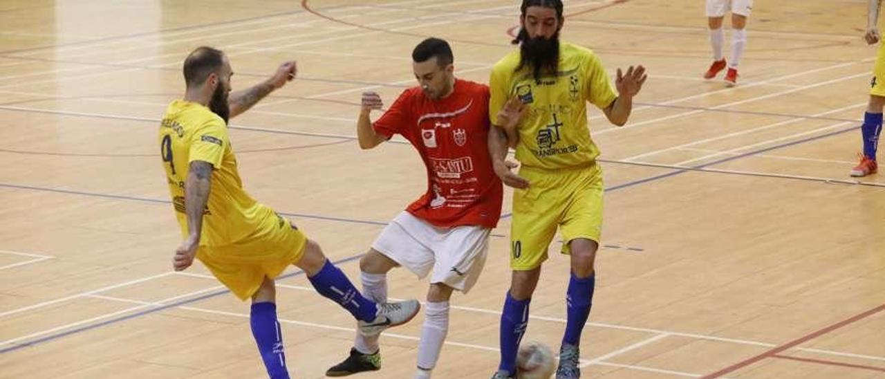 Tres jugadores pugnan por el balón.