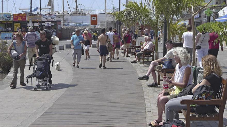 Turistas en el paseo de la playa de Los Cristianos.