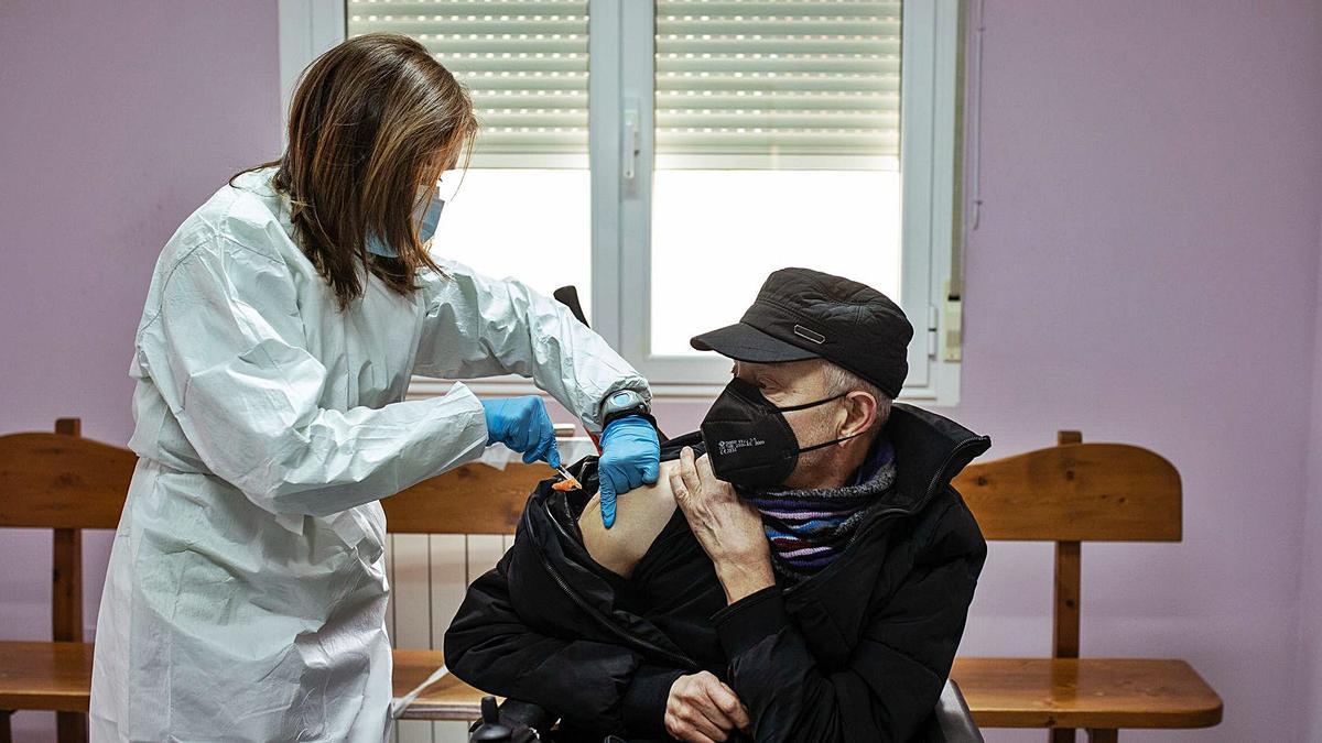 Un hombre en silla de ruedas se vacuna en el interior del consultorio médico de Villaralbo.