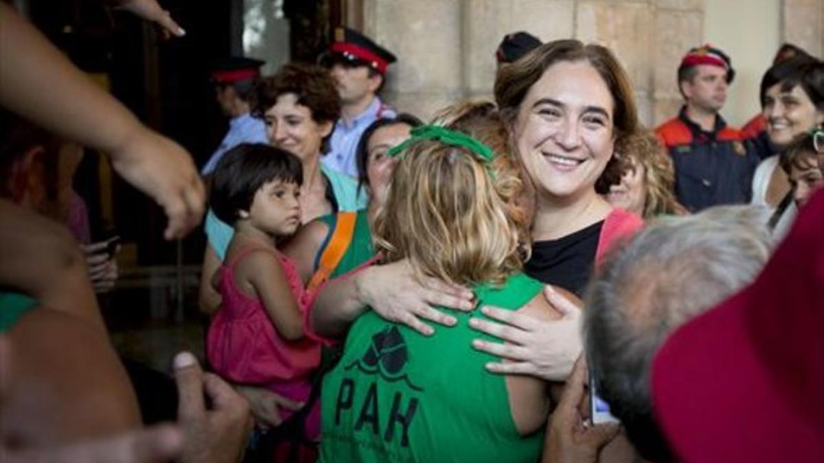 Miembros de la PAH celebran con Colau la aprobación de la ILP de vivienda en el Parlament, en julio.