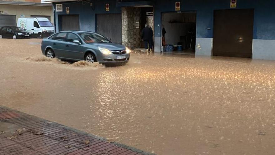 Una calle del barrio de l’Alquenència anegada por el agua. | R. SEBASTIÁN