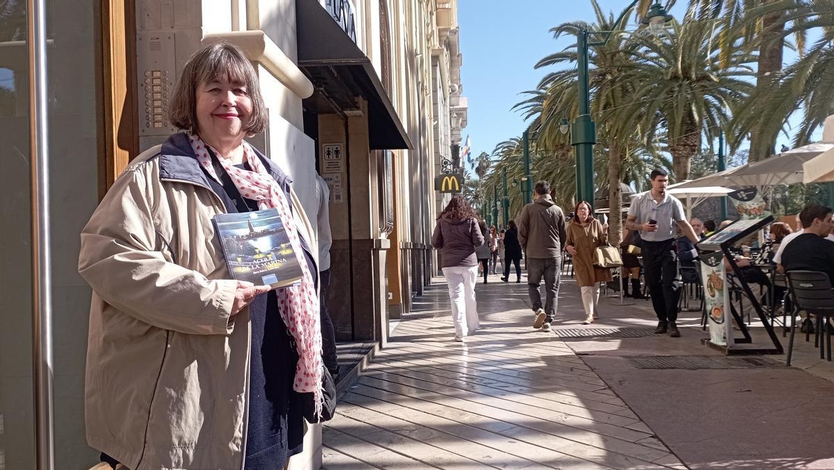 Lola Acosta, delante de su antigua casa en la Acera de la Marina, con su libro de recuerdos de Málaga.
