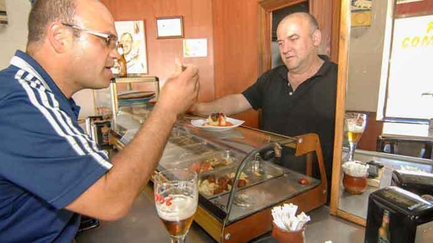 Un cliente del bar París prueba &quot;bacalao de la abuela&quot; al poco de abrirse el certamen