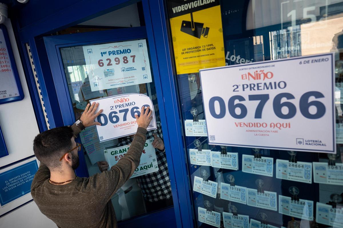 Momento de la colocación del cartel que acredita que la administración Fabe de La Cuesta ha entregado 10 décimos del segundo de El Niño.