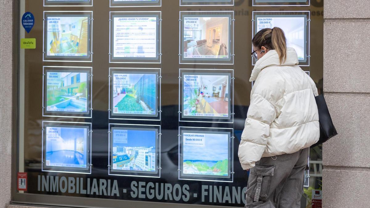 Una joven, ante los anuncios de viviendas en una inmobiliaria de A Coruña.