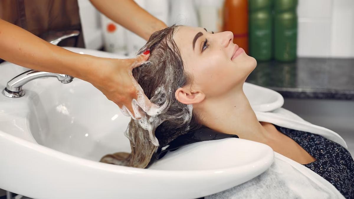 Una clienta se lava el cabello en un salón de peluquería (club estilo)