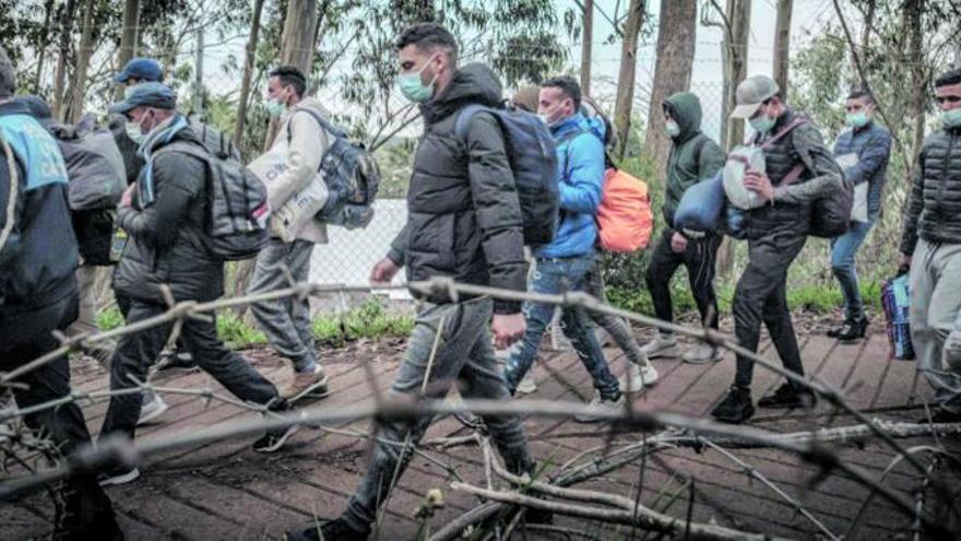 Varios de los migrantes ‘amotinados’ en Las Raíces el lunes en el camino de regreso al campamento en el que denuncian carencias.