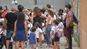 Un grupo de padres con sus hijos a la salida del colegio.