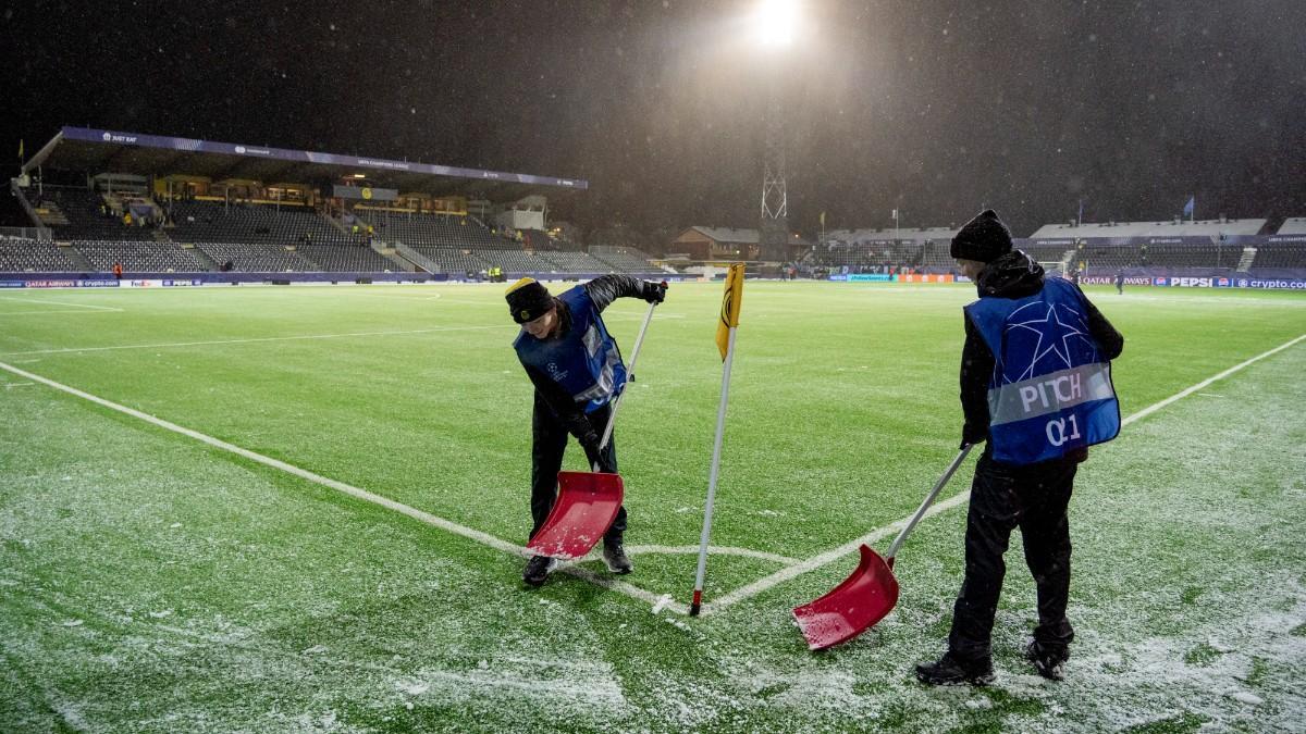 Operarios retiran la nieve y el hielo del césped artificial del Aspmyra Stadion