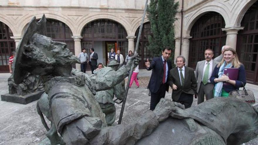 Un hombre contempla algunos de los óleos y la figura de Juan Pablo II.