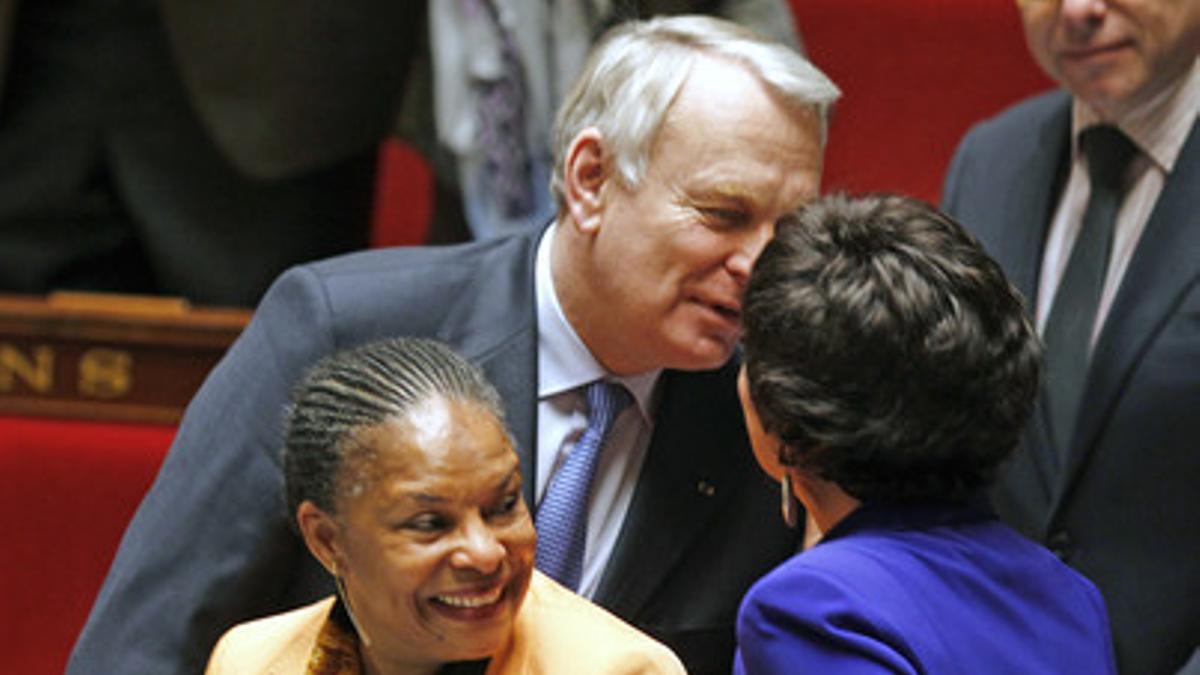 El primer ministro francés, Jean-Marc Ayrault, felicita a la titular de Familia, Dominique Bertinotti (derecha), en presencia de la ministra de Justicia, Chistiane Taubira, este martes.