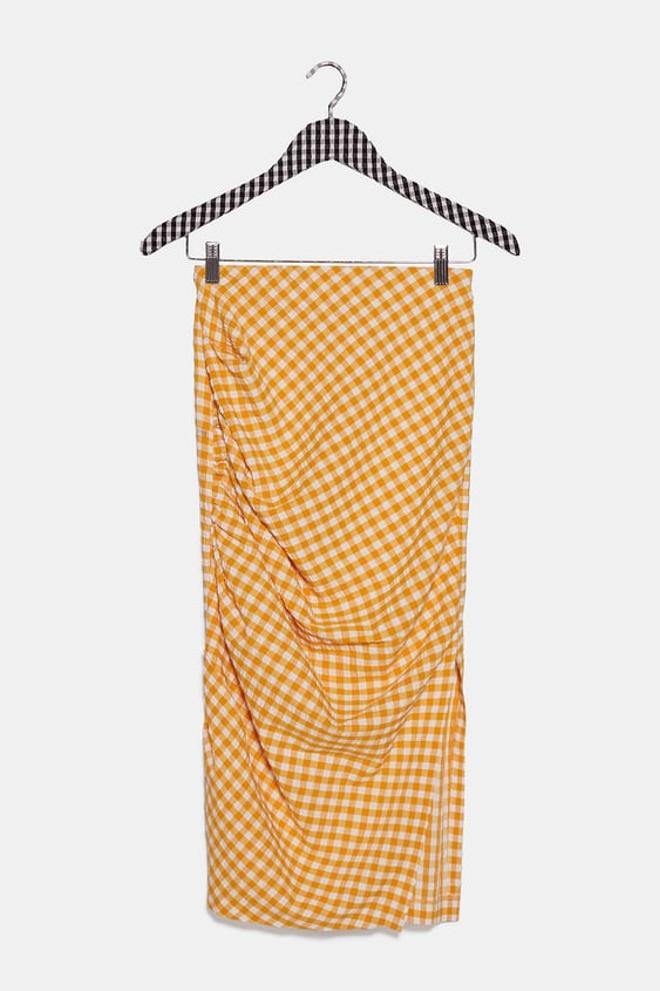 Falda vichy en naranja claro y blanco de Zara. (Precio: 25, 95 euros)